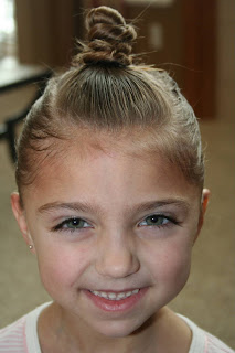 Portrait view of young girl modeling "The Bun-Hawk" hairstyle