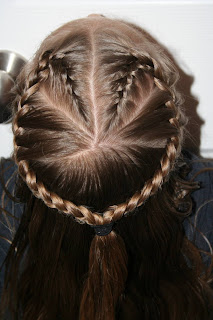 Top view of a young girl modeling “French Designer Heart” hairstyle