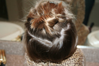 back view of young girl's hair being styled into 3-barrel curl hairstyle on her a-line bob