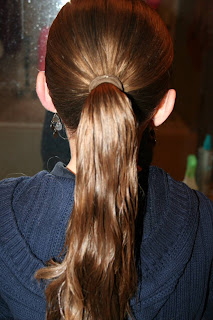 Back view of young girl's hair being styled into "bundled braids" hairstyle