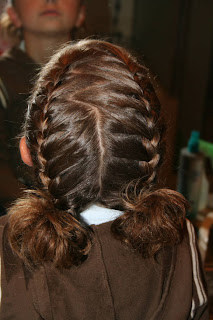 Back view of young girl's hair styled into "Double-French Braids w/Messy Flips"