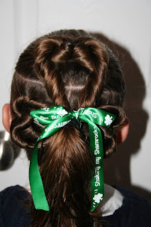 Back view of young girl's modeling "Best Three-Leaf Clover" hairstyle with green ribbon hair accessory